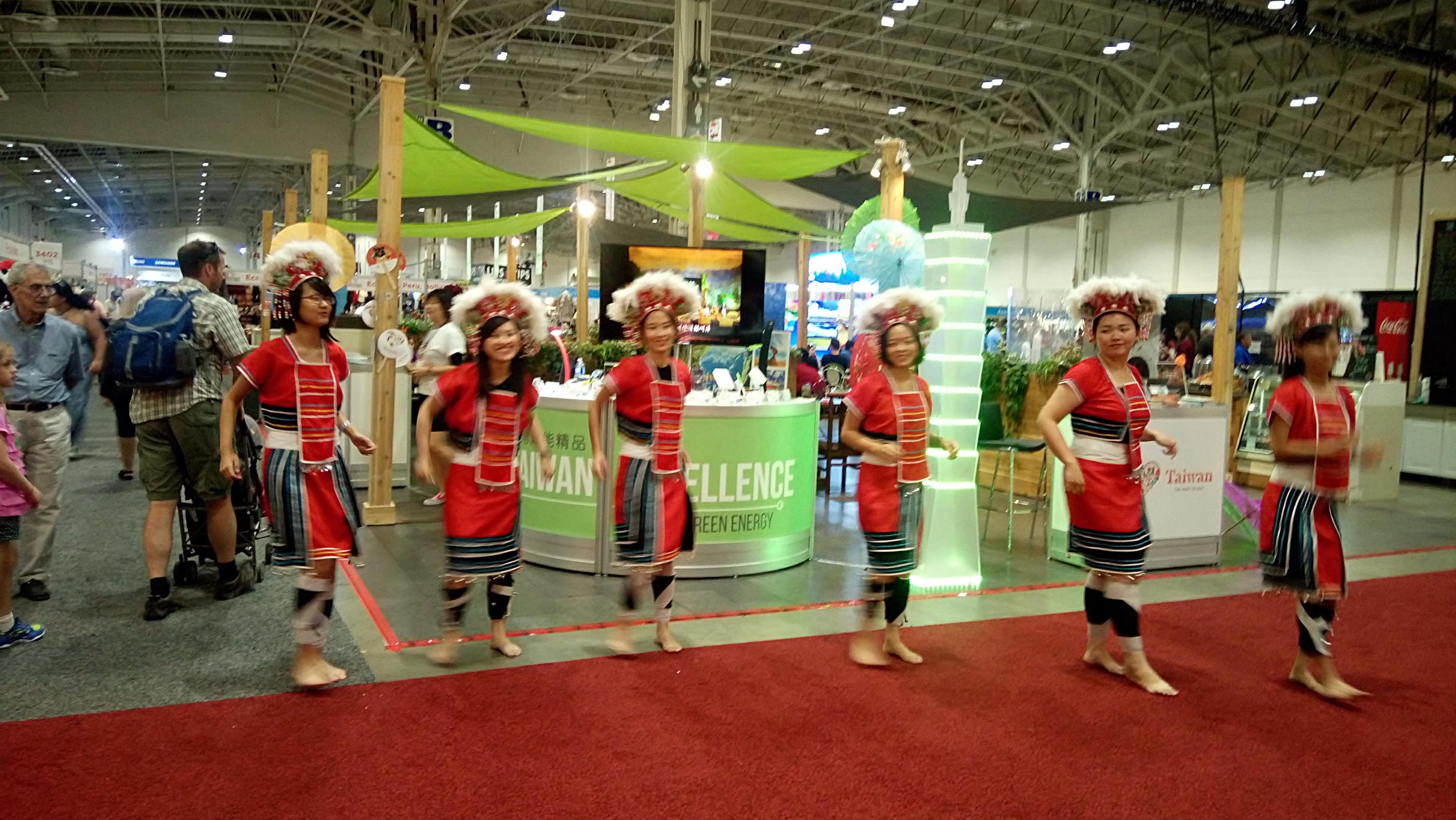 展攤現場有穿著原住民服飾的台灣志工表演舞蹈。