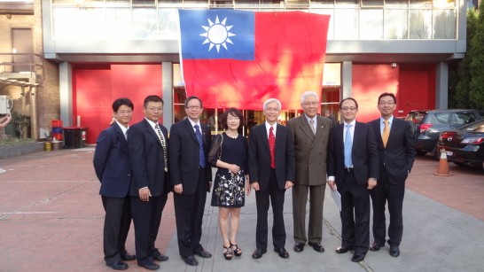 周處長進發偕同仁於會場巨幅國旗前合影