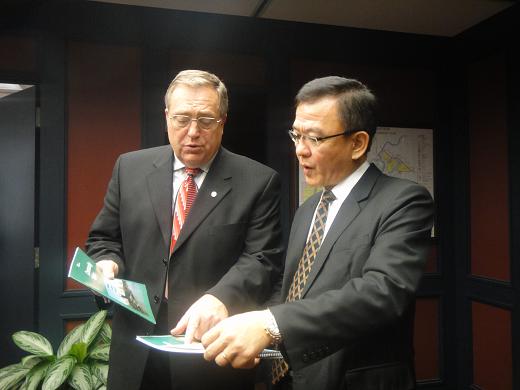 Mayor Atchison shows Director-General Tseng Saskatoon's Strategic Plan 2012-2022