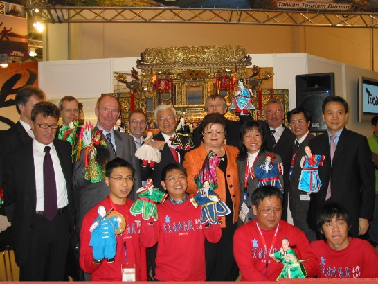本處尤代表與國會議員合影於柏林旅遊展亦宛然布袋戲台前。