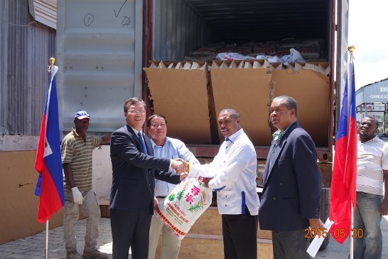 黃大使再求(左2)與海地社會部部長Charles JEAN JACQUES(右2)舉行「幫幫忙基金會」援海一貨櫃食米轉贈儀式。