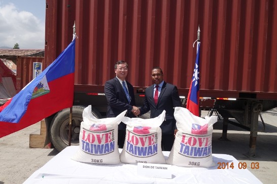 駐海地黃再求大使與社會部長Charles JEAN JACQUES於我政府贈海食米貨櫃前合影。