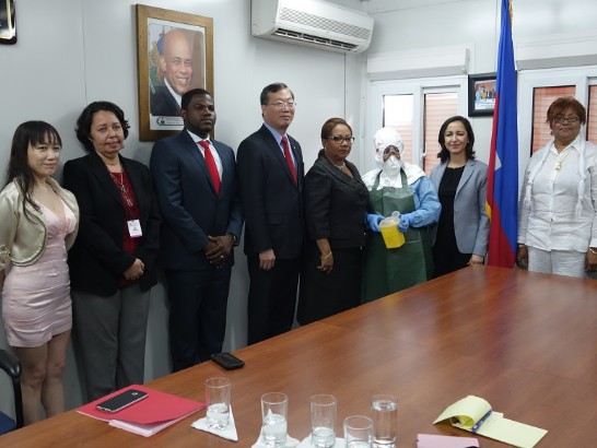 駐海地大使黃再求代表我國與「汎美發展基金會」(PADF)駐海代表Nadia Cherrouk女士(右2)共同將21套抗疫防護裝備贈交衛生部。