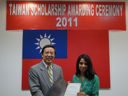 Ambassador Wenchyi Ong awards a certificate to a scholarship recipient. 