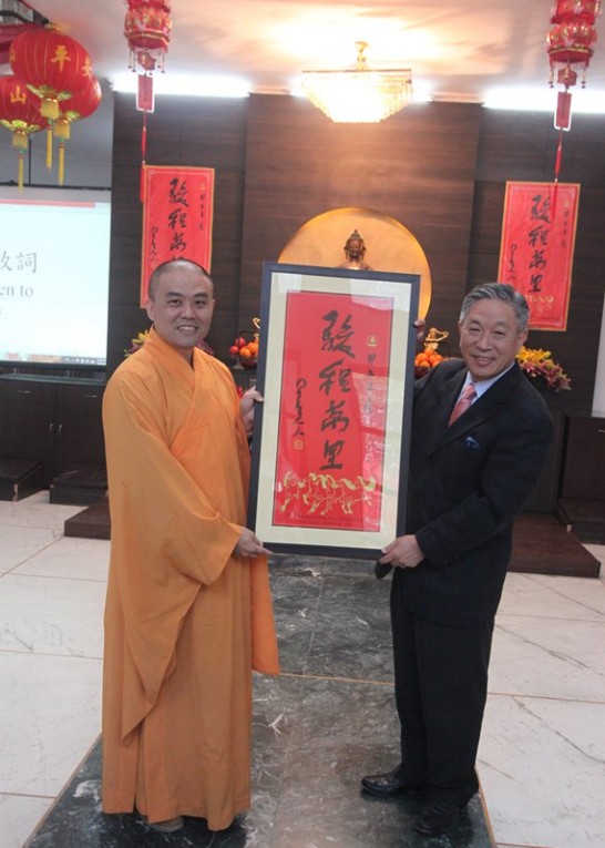 佛光文教中心主任慧顯法師致贈田大使「駿程萬里」匾額。