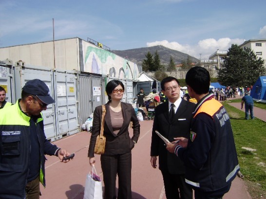 Un’impiegata del Dipartimento della Protezione Civile italiana conduce l’Ambasciatore Yih in visita alla tendopoli dell’Aquila.