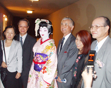 駐日経済文化代表処の朱文清・広報部長(写真右1）の夫人である張懿文さん（写真右4)が、９月１５日、東京の国立劇場の舞台に出演し「藤娘」を華麗に披露した。この日の舞台は張さんが入門している市山流の舞踊公演として行われた「市山会」に出演したもので、張さんは長年にわたる努力が認められ「名取」の免状を取得し、その名取披露に「市山妙扇」として出演したもの。当日は高橋雅二・日本交流協会前理事長(写真右3）、インド公使夫妻をはじめ、台湾や日本のメディア関係者、羅坤燦・台北駐日経済文化代表処代表代理夫妻（写真左1,2)ならびに多くの代表処関係者や、張さんが所属している駐日代表処職員の夫人や女性職員で組織されている「東京フォルモサ婦人会」のメンバーも大勢かけつけ、張さんの努力の成果に盛んに拍手をおくっていた。