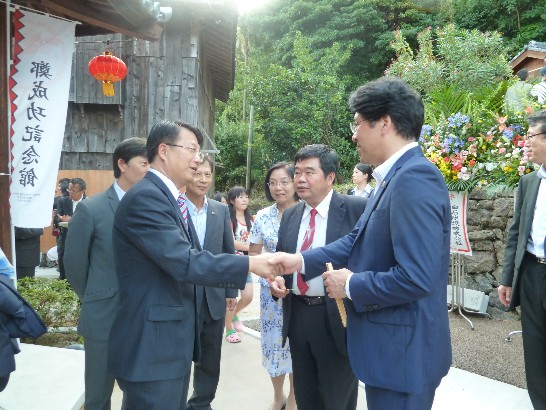 台南市顏純左副市長(左)抵會場與平戶市黑田成彥市長（右）握手寒暄,本處戎總領事義俊居中協助翻譯