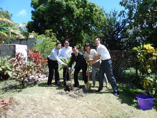 駐館曹大使(中)帶領同仁一齊將樹苗種在大使館北側庭院。