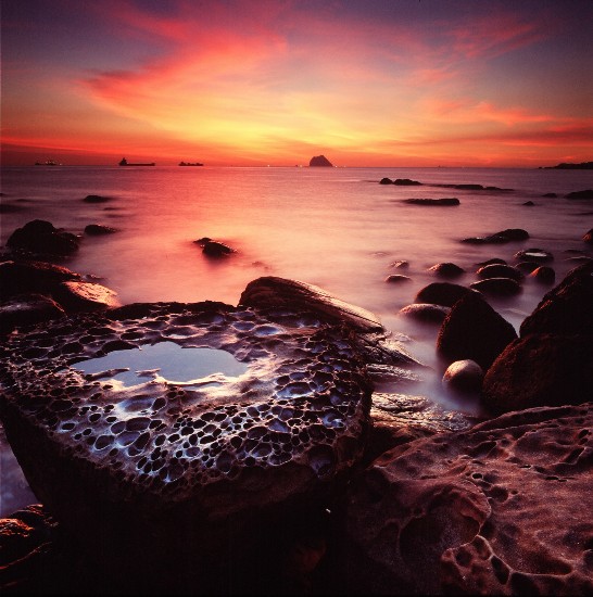 夕陽餘暉映照台灣東北角海岸秀麗的海蝕地形。（鄭凱仁 拍攝）