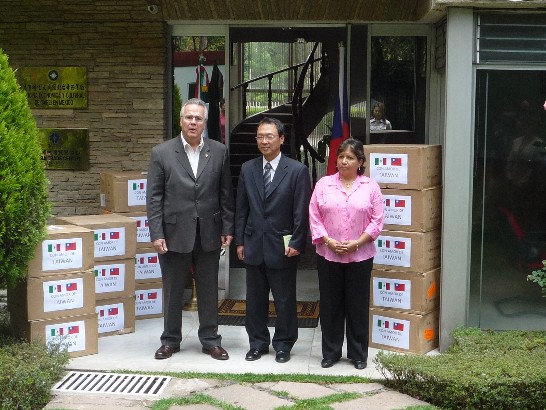 墨西哥國會亞太小組秘書長Javier Castelo參議員及墨國全國護士協會主席Laura Margarita分別從陳代表手中接下一箱上面貼著「來自台灣的愛心」字樣以及兩國國旗的貼紙