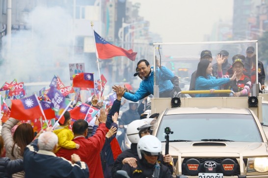 Kuomintang presidential candidate Eric Chu gives high-fives to flag-waving supporters along a street in Taipei. (Jan. 15, 2016, Taipei City, photo by Jimmy Lin)