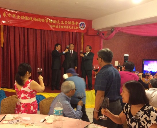 劉大使德立與顧僑務委員丹塵（舞台右ㄧ）及與會之東方市僑社共同舉杯祝福即將離任之張總領事翰鈞（舞台左ㄧ）
