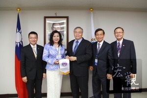 僑務委員會主任秘書張良民（中）致贈僑委會會旗給前來拜會的泰國海華協會訪問團，由團長林來好僑務委員（左二）代表接受。