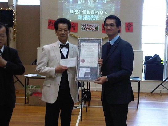 駐處陳組長（右）致贈愛丁堡華人松柏會秋節「台灣蘇格蘭格紋」裱框證書及加菜金，由該會石亞添主席（左）代表接受。