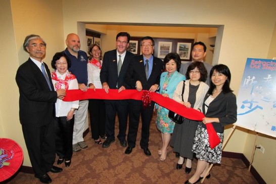 Director-General Shen and Bartlett Village President Michael E. Kelly, middle left, cut the ribbon to open the photo exhibition at the village hall.