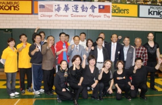 Consul General Ger takes a photo with volunteers of the Double Ten sports meet