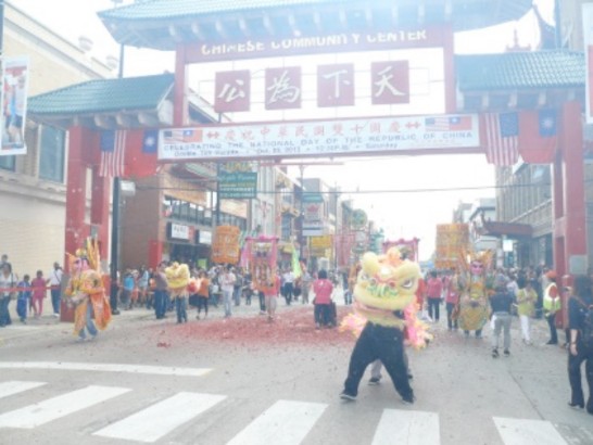 Members of lion dance team and idol dancers parade through the iconic Chicago Chinatown gateway.