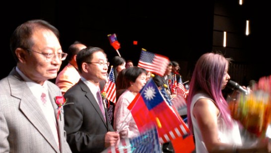 Invited dignitaries sing “Plum Blossom” on stage with the audience.