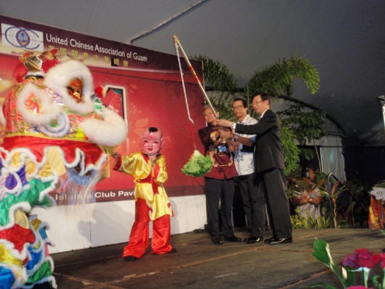 Mr. Joseph Hsu, President of United Chinese Association of Guam, Mr. James Qu, Acting President of Guam Chinese Association, and Director General Paul Wang (from left 1 to 3) receive the good luck from the lion dancing performed by Chinese School's students.   