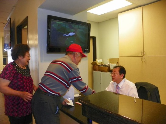 A member of the Taiwanese community applies for passport renewal with secretary Chang serving him at the Cultural Center