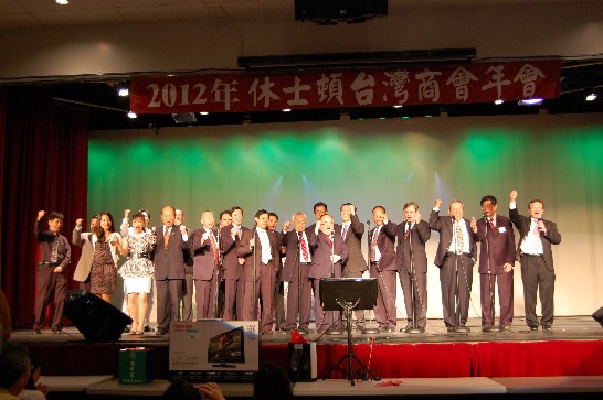 Pictured on stage: new and old presidents of Taiwanese Chamber of Commerce with all of their staffers on board singing a song in their 26th annual meeting