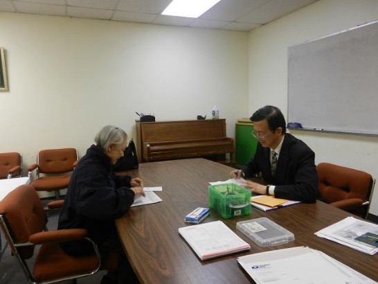 駐休士頓辦事處廖東周處長協助達拉斯鄉親填寫領務申請表件。