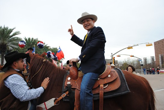 駐休士頓辦事處處長廖東周大使夫婦，全美華埠小姐胡瑞欣，僑務諮詢委員葉宏志，僑務委員鄭昭，中華公所主席伍萬鈞以及校聯會代表坐上馬車參加百餘馬車參加的遊行接受逾十萬夾道群眾的歡呼