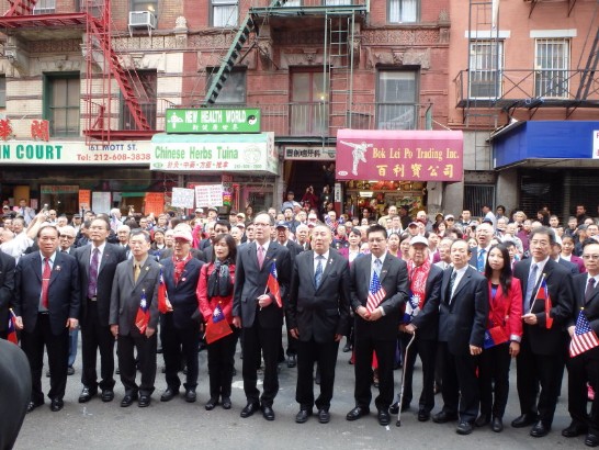 紐約曼哈頓華埠10月10日舉行歡慶中華民國103年雙十國慶盛大活動，由下午1時在紐約中華公所大樓前的升旗典禮揭開序幕，由中華公所主席伍銳賢、美東聯成公所主席蕭貴源、台山寧陽會館主席黃仕初，以及駐紐約辦事處大使章文樑偕夫人虞謹芳女士(左五)等帶領七大僑團代表齊聲高唱國歌及國旗歌。