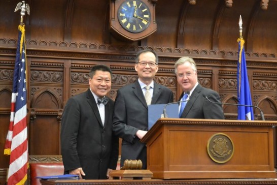 康州眾議會議長Brendan Sharkey(右)代表該州州長Dannel Malloy於議場議室主席台頒贈章大使(中)友我賀狀；左側Tony Hwang眾議員。