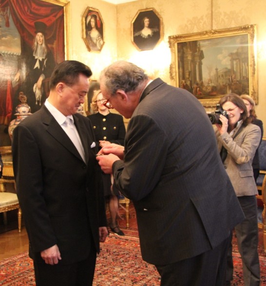 The Grand Master Fra’ Matthew Festing (1st from right) places the medal on Ambassador Larry Wang’s left lapel (1st from left).