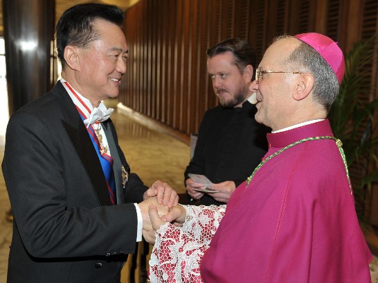 Ambassador Larry Wang (1st from left) shake hands with Secretary Angelo Vincenzo Zani (1st from right) at his reception.