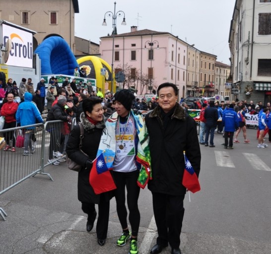 我國選手王秋竣（中間）抵達終點時，中華民國駐教廷大使王豫元夫婦手持國旗迎接祝賀並陪同至選手休息區。