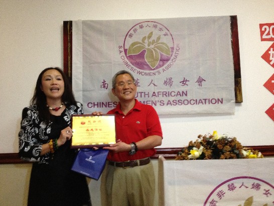 Hwei En Hung of South African Chinese Women's Association presentes an accolade of gratitude to Ambassador Michael Hsu on the third of March, 2013.