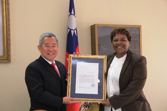Ambassador Pei-yung Hsu hands the scholarship of Mr Mositsani Gabriel Malefetse to his mother