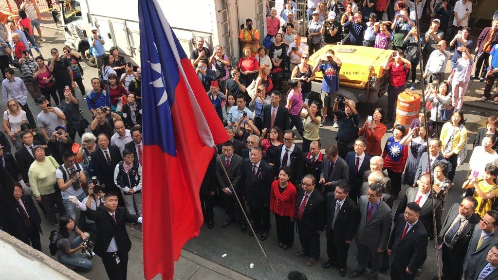 The national flag of the Republic of China is raised in front of onlookers at the Chinese Consolidated Benevolent Association’s Community Center in Chinatown