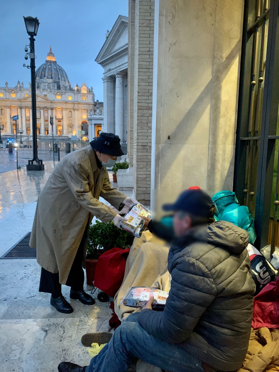 駐教廷大使李世明（左）將印有台灣正在幫忙的物資袋送給街友，不少街友當場感動流淚。
