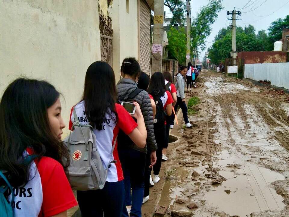 Taiwan Youth Ambassadors walk on the side of a muddy road to Mukti Ashram Sept. 3.