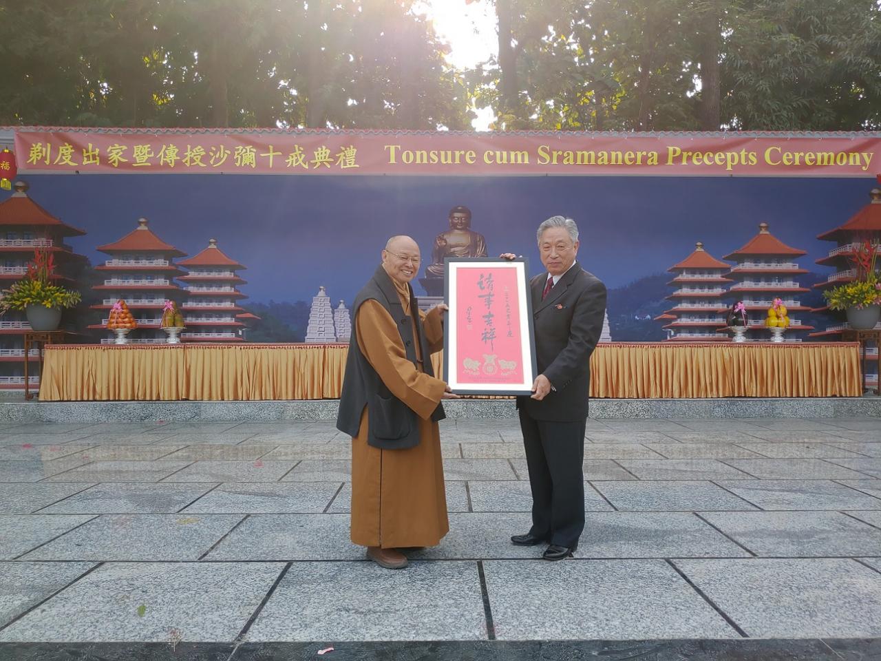 Venerable Hsin Ting (left) presented a calligraphy written by Venerable Master Hsing Yun to Amb. Tien.