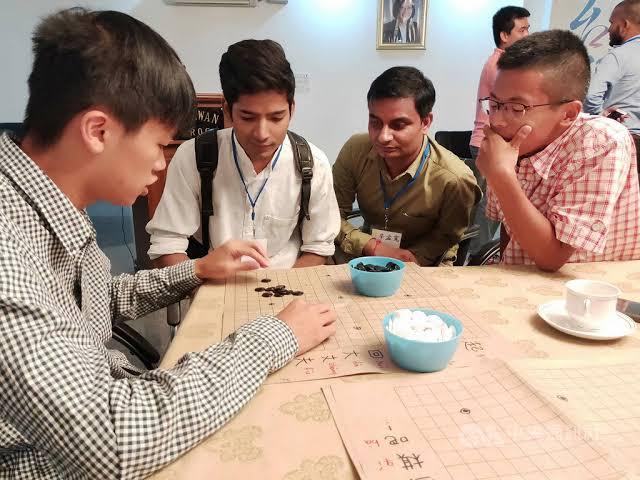A student volunteer from Taiwan sharing his chess skills with an Indian friend.