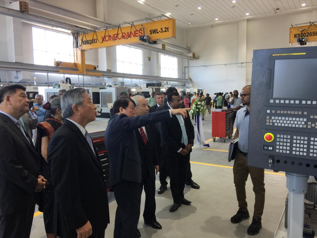 Mr. Jimmy Chu(Left 3), Chairman of FFG, accompanied by Amb. Tien(Left 2), introduced the assembly machine tools to the guests.