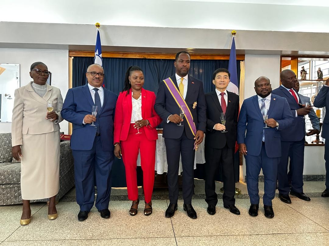 胡大使與潘恩大使(前排右三)、總統委員歐古斯丁(Smith AUGUSTIN，前排右一)、吉爾傑(Dr. Louis Gérald GILLES、左二)、潘恩大使夫人暨總統府新聞室主任Daniella JACQUES(左三)及潘恩大使母親(左一)合影