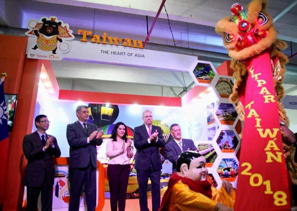 中華民國駐巴拉圭大使館參加本(107)年10月12日至14日巴國觀光旅遊協會(Asociación Paraguaya de Agencias de Viajes y Empresas de Turismo, ASATUR)舉辦的「第15屆巴拉圭國際旅遊展」(Feria de Turismo del Paraguay, FITPAR 2018)，舞獅熱烈祝賀「臺灣館」開幕式。照片為駐巴拉圭大使館丁副參事志華(左一)與巴拉圭觀光部長蒙媞耶爾(Sofía Montiel de Afara)女士(中)及亞松森市長費雷洛(Mario Ferreiro)(右二)合影。