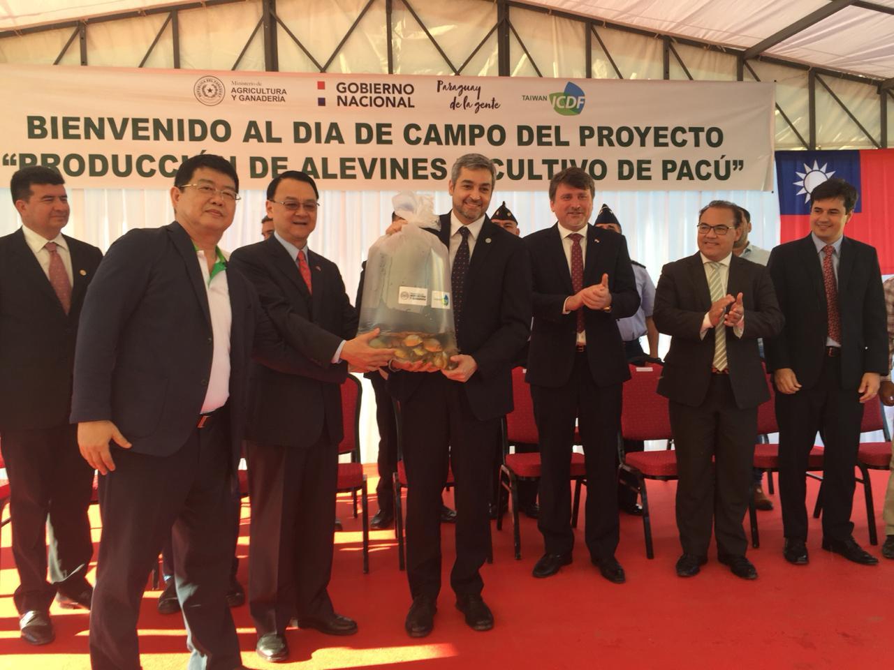 中華民國駐巴拉圭周麟大使於107年11月20日前往Eusebio Ayala市與巴國總統阿布鐸及農牧部長李奇共同主持我國技術團「淡水白鯧魚苗繁養殖計畫」觀摩會活動，圖為周大使象微性將淡水白鯧魚苗轉交予阿布鐸總統，代表「淡水白鯧魚苗繁養殖計畫」移轉給巴國。
