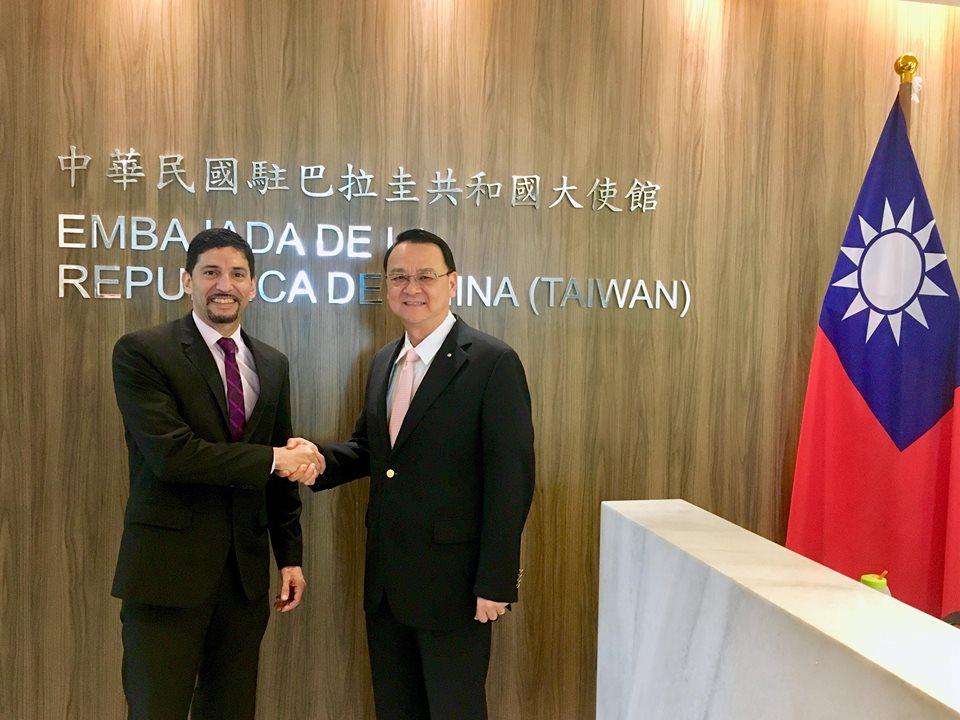 圖為中華民國駐巴拉圭周麟大使與巴拉圭放射暨核能管理局局長古鐵雷斯在駐巴拉圭大使館館牌及我國國旗前合影。