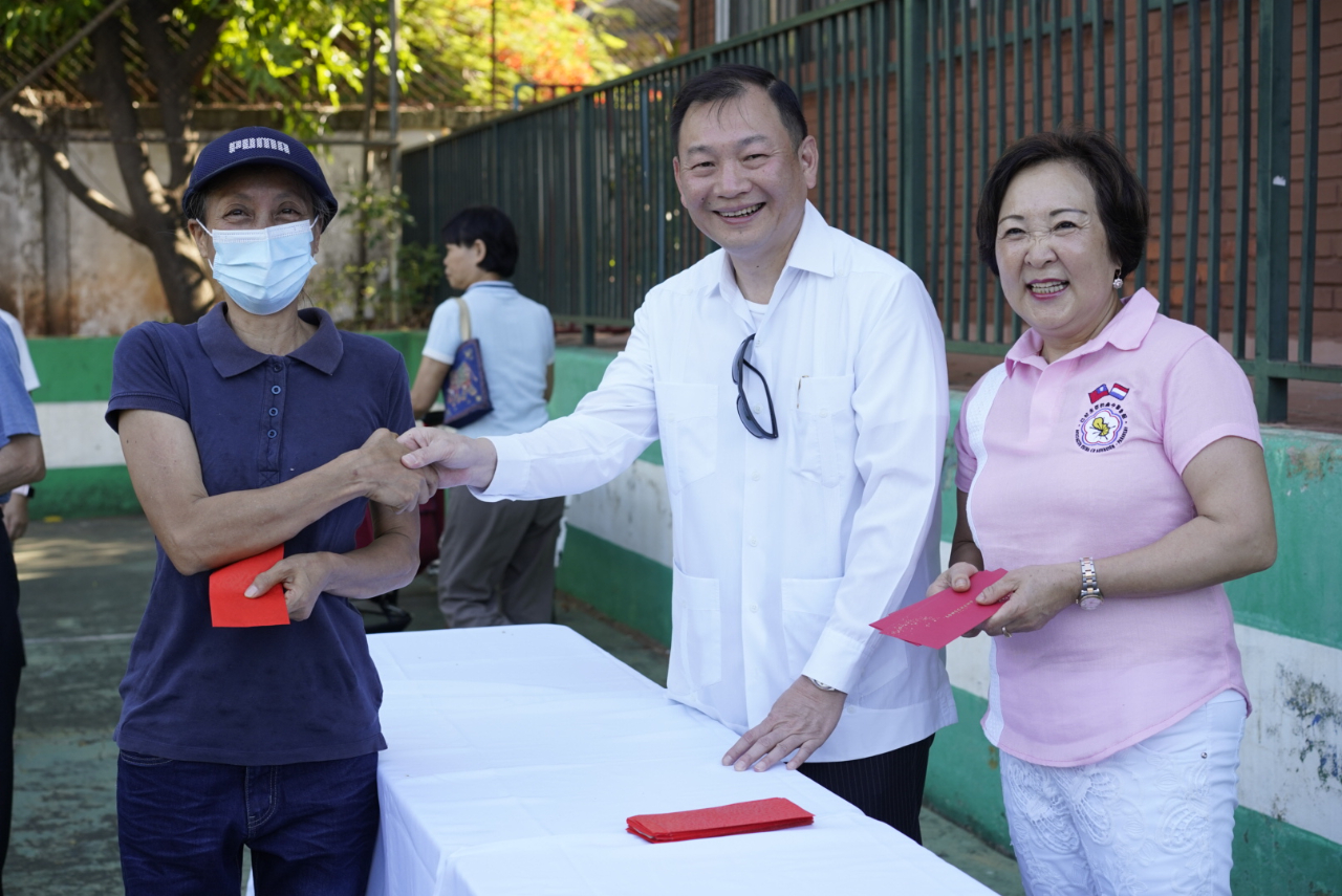 駐巴拉圭韓志正大使與中華會館理事長湯古美桂贈送參加升旗典禮70歲以上僑胞由中華會館準備的新年紅包。