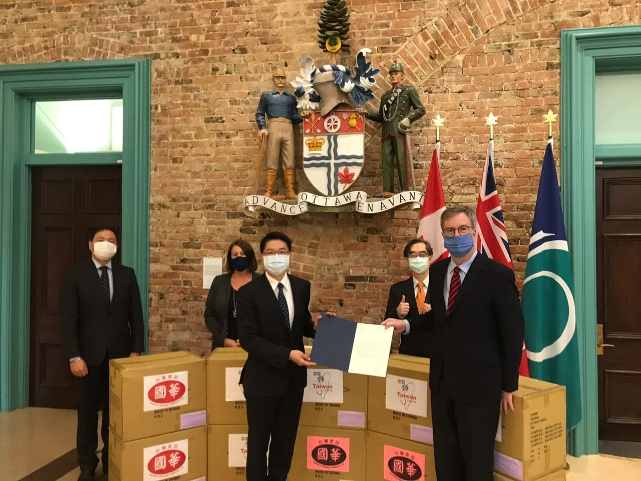 駐加拿大代表陳文儀（前左1）10月22日拜會渥太華市長華森（Jim Watson，前右1），並代表台商國華台灣食品公司，捐贈2萬片台灣口罩給渥太華市政府。