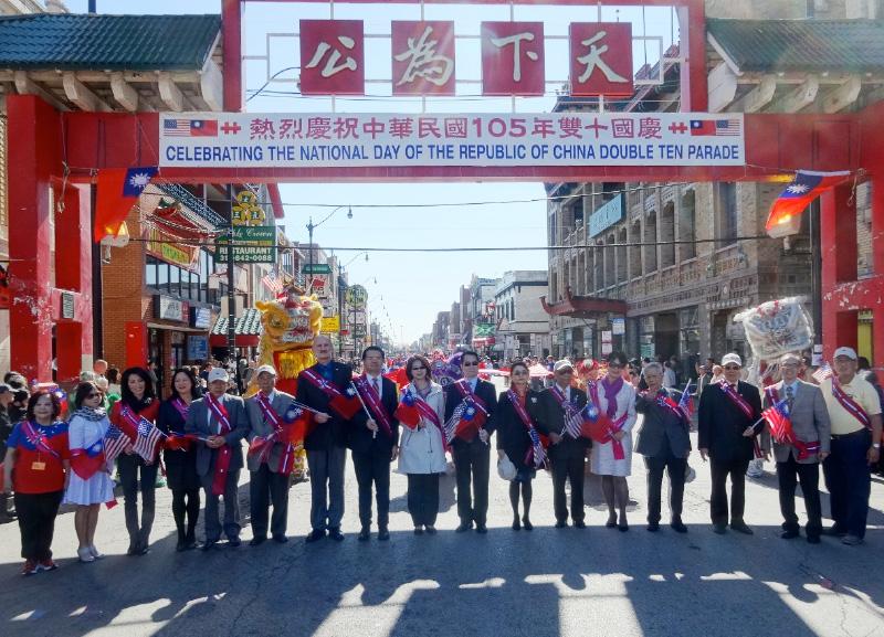 何處長於國慶花車遊行前與貴賓在華埠牌樓前合影。