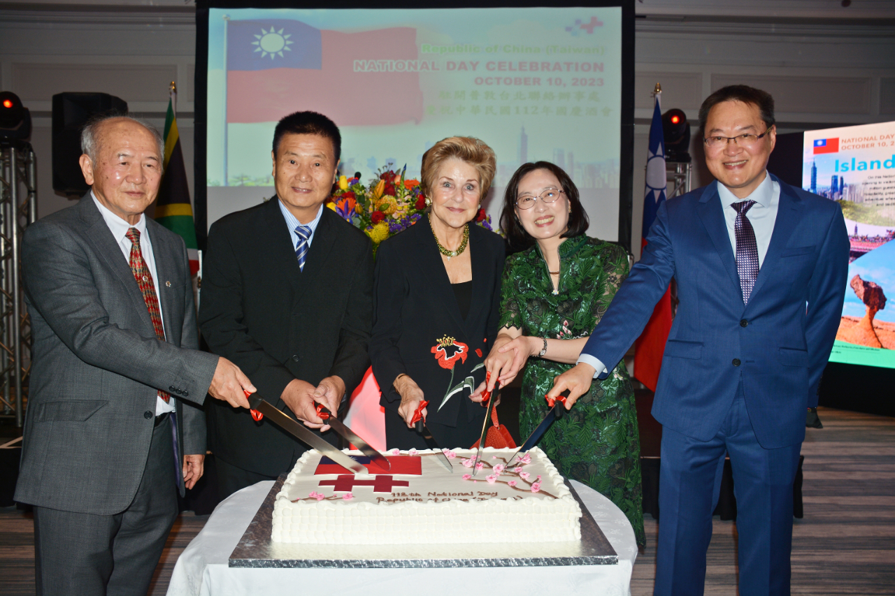 陳處長瑩莉及夫婿汪哲仁博士（右一及右二）、南非前總統戴克拉克夫人Elita de Klerk（右三）、開普敦台灣商會會長王國揚（左二）、僑務諮詢委員林錦華（左一）共同切蛋糕慶賀112年國慶