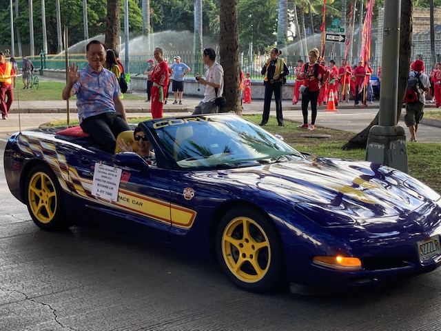 林暉程處長夫婦在遊行車隊中向群眾致意